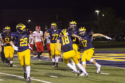 TOUCHDOWNS FOR DAYS: After scoring a touchdown, Jack Healy (#17), senior wide receiver celebrates with teammates, including senior quarterback Daniel Jenkins (#18). The Titans beat Niles West  56-34. Other scorers included senior Captain Ryan Janczak with four touchdowns, senior fullback Calvin Sailer with two and senior Captain Owen Boyle with one. 