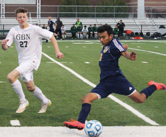 MOHAWK MEN: Striding towards the ball, senior captain Javier Ayala (left) looks to make a pass to a teammate down the field. Looking for an open player, senior captain Iñaki Bascaran winds up for a throw-in (right). The Titans shaved and styled their hair into mohawks in preperation for the playoffs, but eventually lost to GBN in double overtime in a penalty kick shootout. Photos by Jacqueline DeWitt