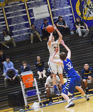 Ballin’ Boys: Looking for an opening , Junior Matt Genacopolous (#23) makes a move in front of a defender (left). Senior captain Jimmy Martinelli (#33) jumps to shoot a three in front of New Trier defender (right). The Titans aim to place top three in conference.