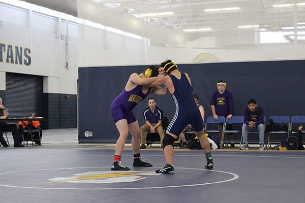 FIGHT TO THE FINISH: Junior Paul Jo goes head-to-head against a Waukegan wrestler on Jan. 16. Jo finished with an individual win (left). The men beat Waukegan with a final score of 51-24. 