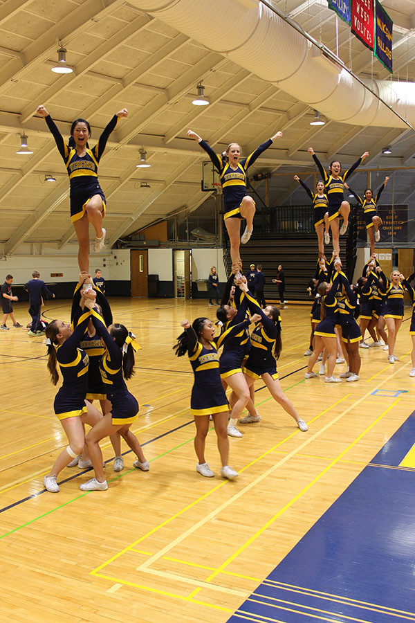 HANDS UP: Looking up, Titan bases suport senior flyers Suzy Whiting and Julia Park in a pyramid. The Titans’ competition season is now over; however, they will continue to cheer at the remainder of the home basketball games. 