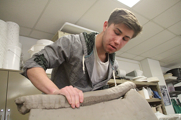 COILING TO THE TOP: Using stoneware clay to create a coil pot, senior Alex Remeniuk works on a piece of pottery he hopes to finish in time for the AP Art Show. Remeniuk was able to further his passion for pottery through winning South’s William H. Schreiner Memorial Arts Scholarship, which brought him to New Mexico for a pottery class.