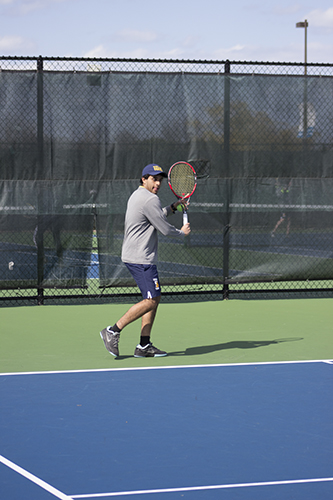 HARD HITS: Swinging his racquet, senior Vinny Ahluwalia sets up to hit a forehand during preparation for his next match.