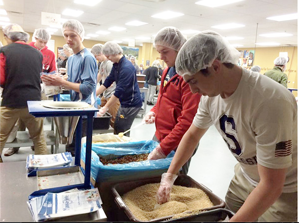 BLAX GIVES BACK: Packing food through the Feed My Starving Children organization, seniors Andrew Marziani, Bobby Quinn and other members of the menís lacrosse team packed 24,192 meals for starving children. This service will help feed 66 children for a year and is one of three community service events the men have participated in this year. Photo courtesy of Will Jeffery