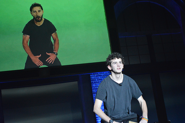 SERIOUS ON STAGE: Striking actor Shia Labeouf’s signature pose on stage, senior Jake Biales entertains audience members during one of Comedy Troupe’s skits for this year’s Variety Show. Through both his participation in Comedy Troupe skits and his YouTube channel, Biales says he wants to be able to craft and tell stories.