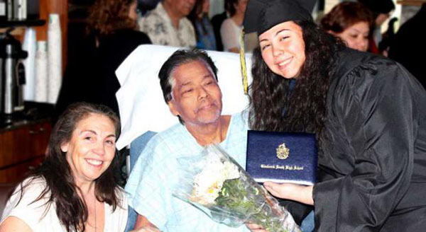GRINNING GRAD: Beaming proudly with her parents, senior Bryanna Hernandez graduates from South early on April 14. She did so in order to ensure that her father, who was diagnosed with gallbladder cancer earlier this year, could witness her graduation ceremony during his last days. 