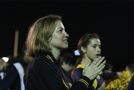 FUN-LOVING FAGEL: Clapping to the Titan fight song, Fagel enjoys the atmosphere of a September football game (bottom right). Fagel says her first year was a huge success, and she says that she loves being a principal again.