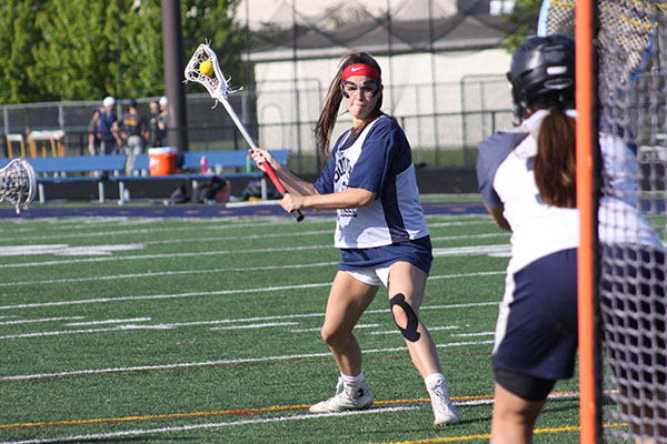 SHOOTING FOR SUCCESS: Progressing through her shot, senior captain Sarah McDonagh practices her form during a scrimmage before the playoffs. The Titans won their first playoff game against Barrington by a score of 16-4 on May 18. 