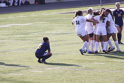 

RAW REACTION: Crouching down on the Trevians home field, junior defender Cassidy Price reacts by holding her hands to her face as she watches the Trevians celebrate after they scored in overtime. The Titans lost to the Trevians by a score of 0-1 on May 24, ending their season.