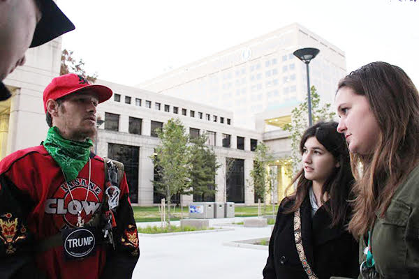 Civil Communication: Standing to the side, Oracle editors, Anne Marie Yurik (front) and Alexandra Sharp (back) interview a Trump supporter who attended the Trump resistance rally held in Indianapolis. The rally was used as a way for individuals to voice their concern of a Trump presidency. Photo by Yoon Kim 