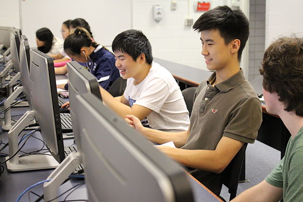 BINARY BROS:  Working with his fellow AP Computer Science classmates, junior Kevin Choi (right) smiles as he completes a line of code. The Computer Science curriculum revolves around providing students with a realistic and usable education in technology. 