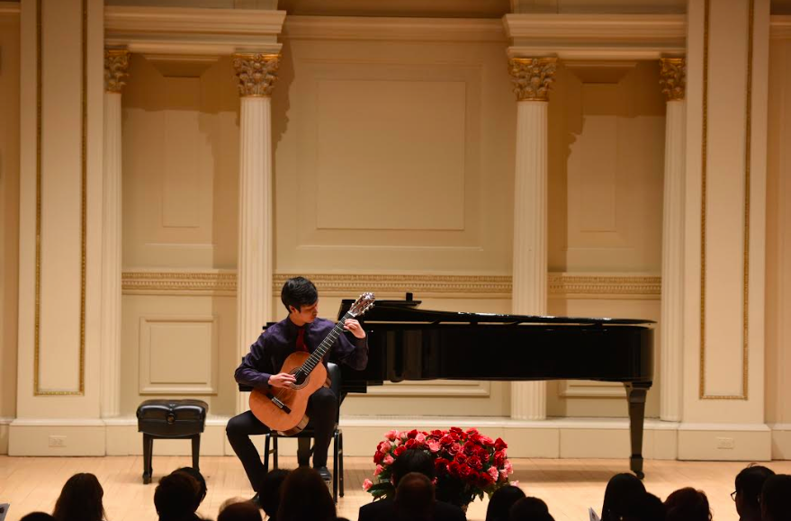 Jammin Jeremiah: Performing at an event, junior Jeremiah Yang plays the classical guitar in front of an audience. According to Yang, he plays mostly classical pieces on the guitar. 
