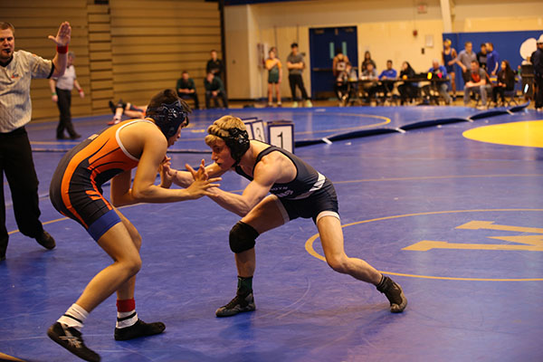 Preparing to take down his opponent, senior captain Ethan Bond, 132 pounds, wins against Bufflo Grove at the Regional tournament on Feb. 4. The team continues to improve each practice and meet and hopes to win a sectional title this Friday, Feb. 10, according to head coach Pat Castillo. 