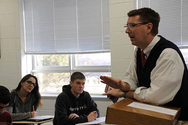 EXPANDING   UNDERSTANDING:  Standing at the front of his classroom, AP Government teacher David Kane lectures his class on the dayís lesson. The Social Studies Department decided not to extend the course to two full semesters for the next year. 