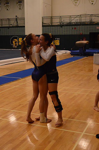 Hugging her older sister, Hannah (right), freshman Jenna Hartley (left) celebrates after finishing her beam routine on Dec. 9, 2016 at GBN. They both compete for GBS and club teams. 