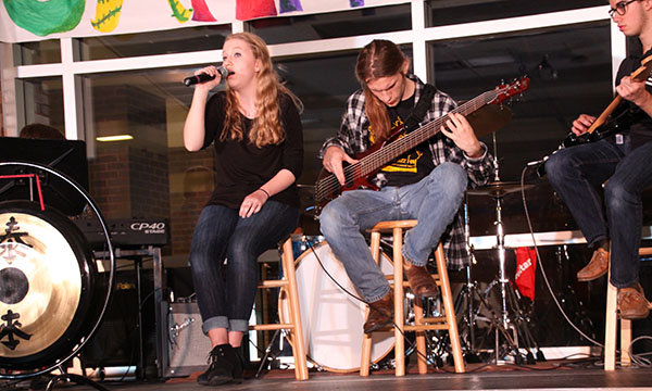 Mindful music: Playing on stage, junior Megan Heublen, sophomore Jack Sundstrom (left) and junior Jack Quinones (right) perform at Jamnesty, April 13. The students contributed to the show and to peace week, raising awareness and playing music.