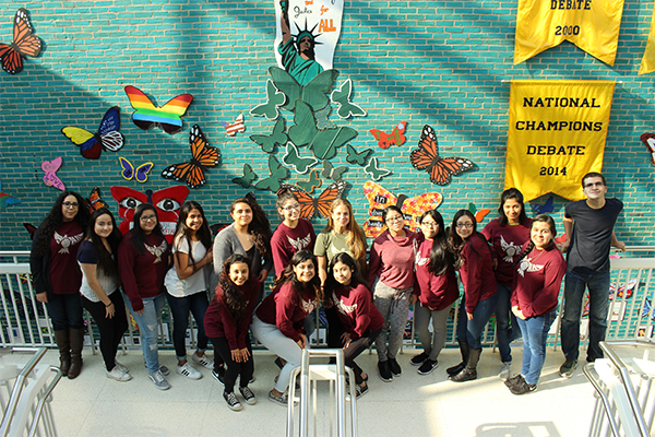 SOARing Toward Equality: Posing in front of Students Organized Against Racismís (SOAR) art display in the old pit, SOAR members admire their hard work. SOAR created the display with the intent to raise awareness for the hardships experienced by immigrants, with members Annabelle Manjooran, Sana Bouacha and Debby Kim coming in during spring break to work on the project alongside junior Lesly Zavalaís leadership to turn the clubís vision into a reality.