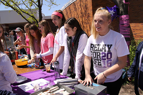 SPRING SMILES:  Selling sweets for Cure Club, seniors Mary Kate Magnot and Mary Grace Noteman help raise funds and awareness for cancer research at this years Spring Fling celebration. The event, which included live music, food trucks and games took place on May 5 during all lunch blocks.