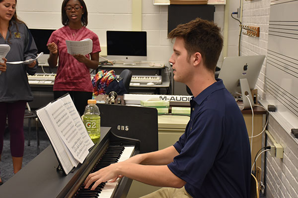 SINGING SHELLARD: Playing the piano for South’s choir group Chambers, new co-choir director Robert Shellard helps students to improve their vocals. Shellard himself was a part of Chambers prior to his graduation in 2009. 