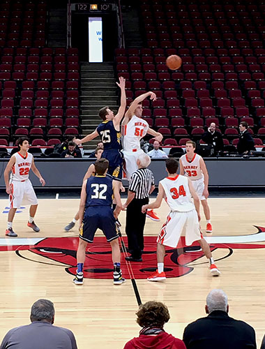 Starting a play, junior Mac Hubbard tries to tip the ball to one of his teammates. The Titans played at the United Center on Dec. 9 against Hersey high school and won 42- 38.