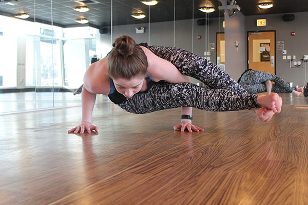 IN THE ZONE: Concentrating on her eight-angled pose, senior Alexandra Anderson practices yoga at Core Power Yoga Studio (above). Gazing at her hand, Anderson strikes a Lord of the Dance pose (below). Anderson started practicing yoga three years ago and intends to continue into the future. 