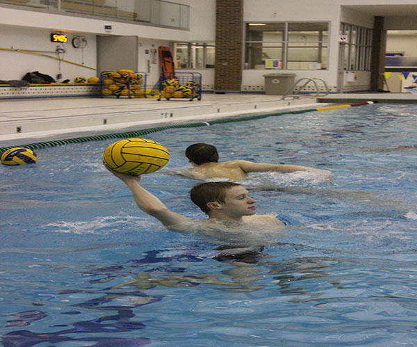   Getting ready to throw the ball, junior Ryan Meyers (left) looks for an open teammate to pass the ball to. Recieving the ball, junior Cameron Schulte catches a ball thrown to him during a morning practice. The waterpolo team has a 9-1 record so far this season