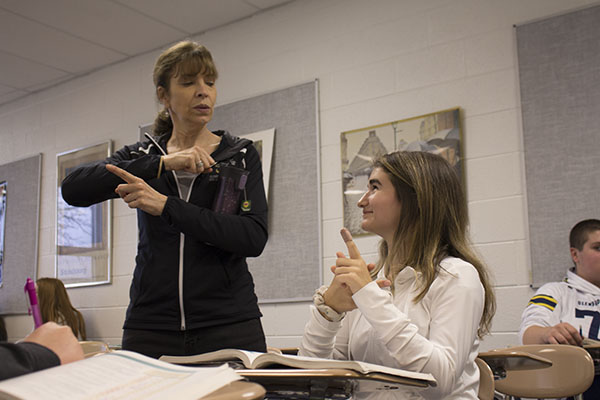 SIGNS THAT SHINE: Demonstrating a new sign, Rosemarie Carsello, American Sign Language teacher shows sophmore Kendall Grenolds a new phrase in sign language. The American Sign Language class participates in events like Silent Weekend in order to immerse students in Deaf culture. 