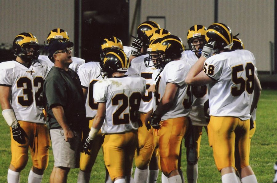 TIME’S UP FOR TITAN: Talking to a football player, Mike Noll, former head coach of Glenbrook South’s Football Team and social studies teacher, spends time on the football field with the team. Noll has spent 14 years working at South.