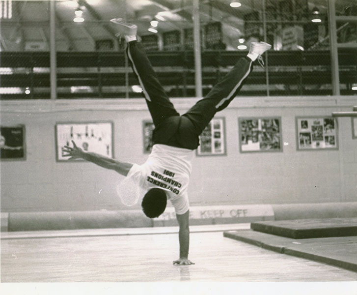 REMEMBERING THE RETIREES: Standing on one hand, Phil Carello demonstrates his experience in gymnastics (above), as he helped coach the men’s gymnastics team for 16 years until 2005, and is now retiring after 21 years as a staff member.  