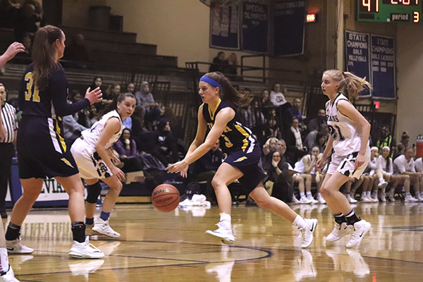Dribbling through the defense, senior Libbie Vanderveen (center) attempts to score against the New Trier Trevians on Feb. 1. The Titans lost to the Trevians by a score of 60 - 33. 