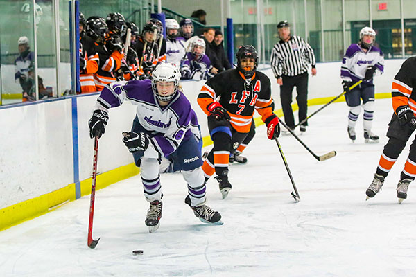 Chasing after the puck, junior Ella Hackett skates past players from Lake Forest Academy. The Glenbrook girls hockey team beat the Caxys 7-0.