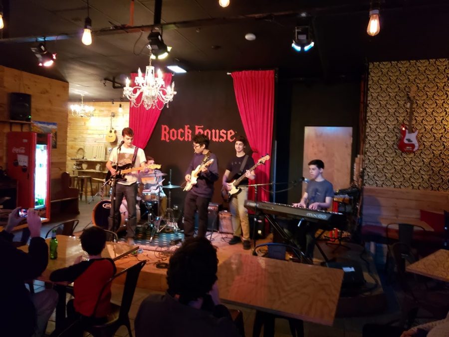 LIGHTING UP THE ROOM:   Performing onstage at the Rock House (from left to right) sophomores Danny McNeela, Sam Collett, Yeon Park, Jeremy Bernstein and Lev Sheinfeld have been playing together as the band Livingroom since August of 2018. In the future the band hopes to possibly record a new single for Spotify and iTunes. 