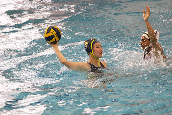 Looking to pass, senior Nomun Saintur prepares to throw the ball as an Evanston Township defender attempts to block it. The Titans lost to the the Wildkits 15-7 on April 6 at the Titan Co-ed Tournament.