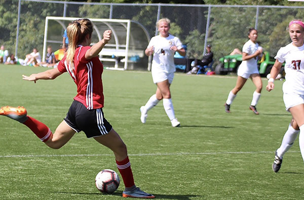 Aspiring Athlete: Making a daring pass across the field, junior Grace Diehl shoots for gold as she plays for the soccer team Eclipse North, featured in both pictures above. Diehl explained that it has been a major aspiration of hers since a young age to play soccer at the collegiate level.