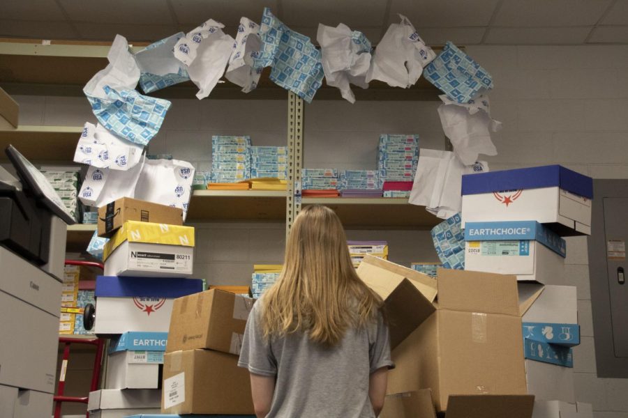 Surrounded by reams of paper, a student feels distressed about the amount of paper used daily here at South. Each day, the school uses 67,516 pieces of paper, of which 45,000 are printed in South’s print shop.