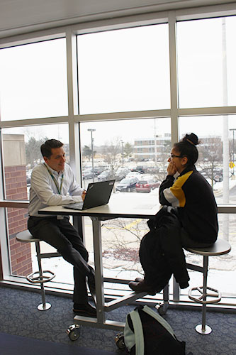 Mentoring Mark: Chatting in the hallway, spanish teacher Mark Bauman and junior Sam Isaac meet for their mentoring session. Photo 