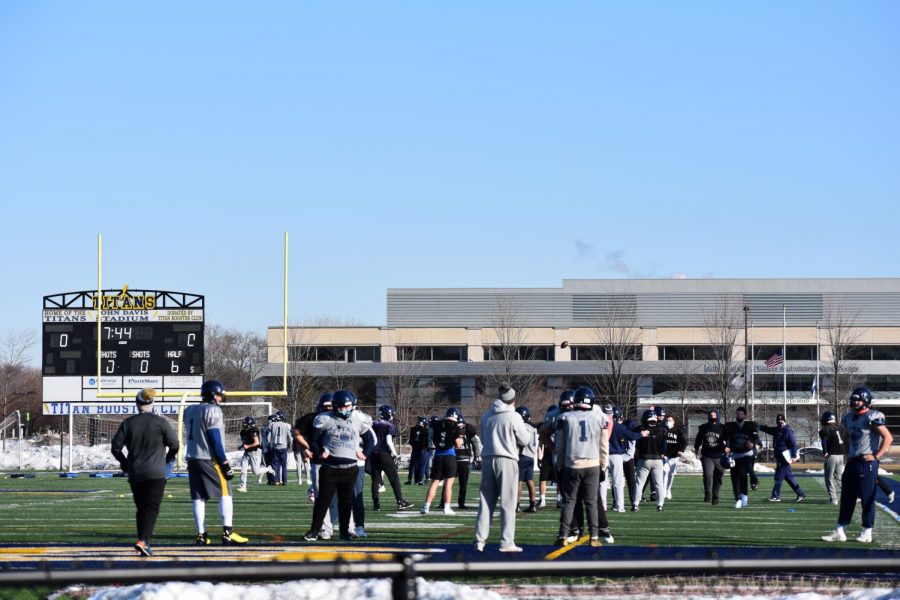 Bouncing back: Running through the playbook, the varsity football team holds a cold, March Saturday morning practice on the turf nearly two weeks before their first game. 