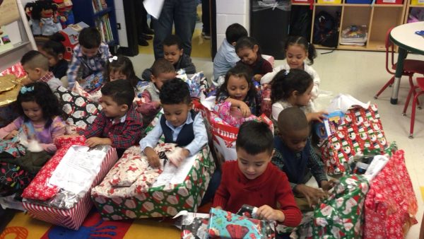 Like Christmas Morning: Elementary school students at John Hayes Community Academy open their presents provided by Secret Santa Inc. The charity aims to deliver presents to students all across the Chicagoland area. Photo courtesy of Jack Conlon