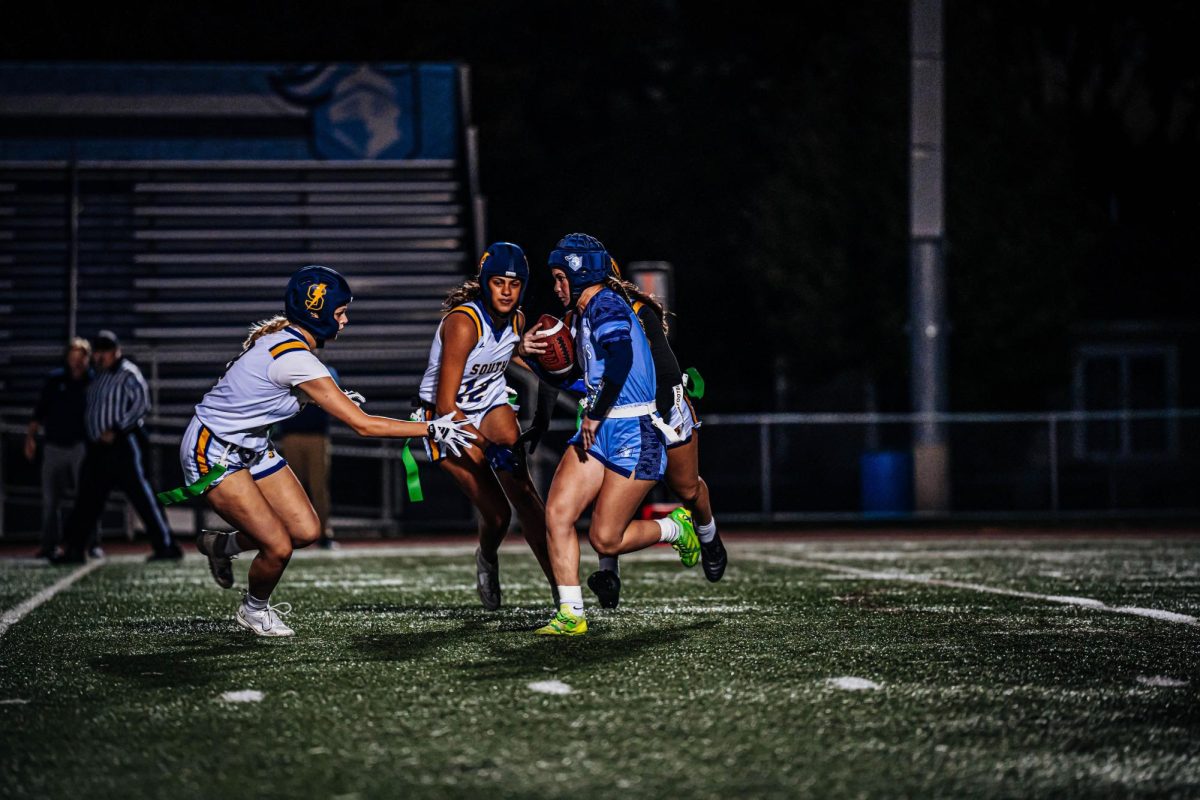 BINNEY BEATDOWN: Binney (left) lunges for the flag and is face to face with a Prospect player (right) during the Regional
game on Oct. 10. South’s tenacity landed them a 12-6 win.