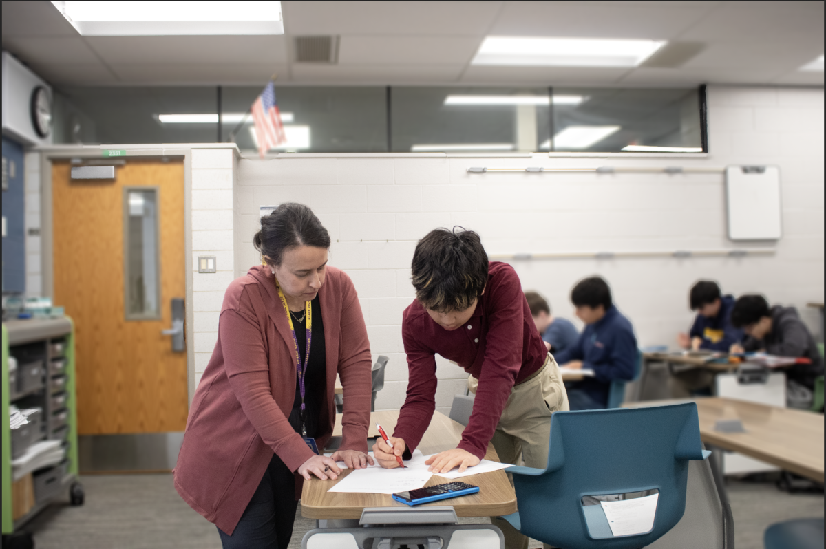 MATH IN MOTION: Math Teacher Rachel Fisher (left) guides eighth grader Adam Park (right) through a math problem during Honors Pre-Calculus. Fisher’s hands-on approach encourages collaboration and builds student confidence in tackling complex problems.