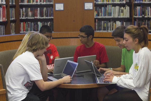 In the IMC, students collaborate using their Chromebooks. No longer limited to the computer labs, freshmen, sophomores and juniors can access the internet and Google Apps anywhere in the school through their devices. Photo by Cormac OBrien.