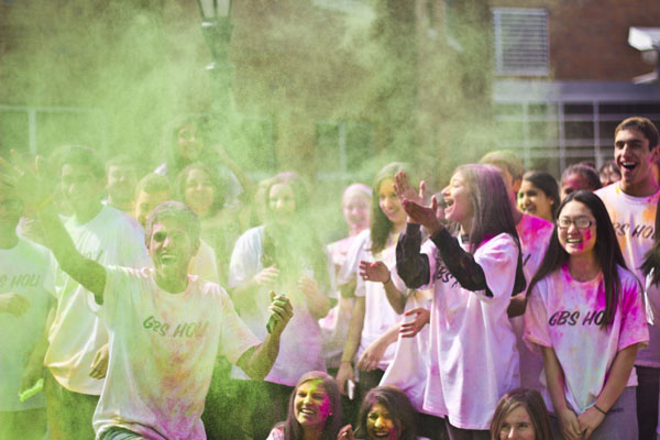 COURTYARD COLOR: Armed with packets of neon powder, Desi Club leader Tom Olickal sends more color into the crowd. Members of Desi Club and Eastern Religions students commemorated Holi, the Hindu spring festival of color, April 2.