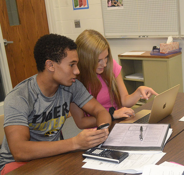 TECH TEAMWORK: Problem solving together, juniors David Magloire and Taylor Mandell use technology as an aid in completing a math assignment. Technology use in the classroom has become much more common at South, expanding to include the use of cell phones for academic purposes.
