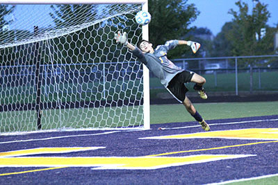 
ADAMOPOLOUS IN THE AIR: Warming up for the game against Palatine, senior goalie Perry Adamopolous dives to save a shot on goal. The Titans are 7-6-2 so far this season.