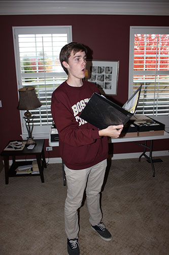 SINGING WITH SOUL: Sight-readng his sheet music, senior Ethan Larson  practices music from one of his many singing groups. Larson serenades audiences as a member of Nine, Scat That! and Chamber Singers. Photo by Sean Dolan