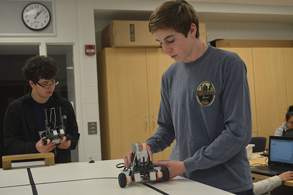 ROBOTIC ROUTES: Adjusting the settings on his robot, sophomore Colb Uhleman (front) attempts to perfect its programming. Uhleman acts as a mentor to freshman Aidan Sochowski (not pictured) as a part of the STEM Learning Community buddy program. 