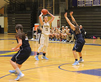  Looking past a defender, junior Carie Weinman (middle), prepares to make an overhead pass to an open teammate on the inside. Weinman is a returning starter. The Titans beat Prospect High School by a score of 50-39 on Dec. 12.