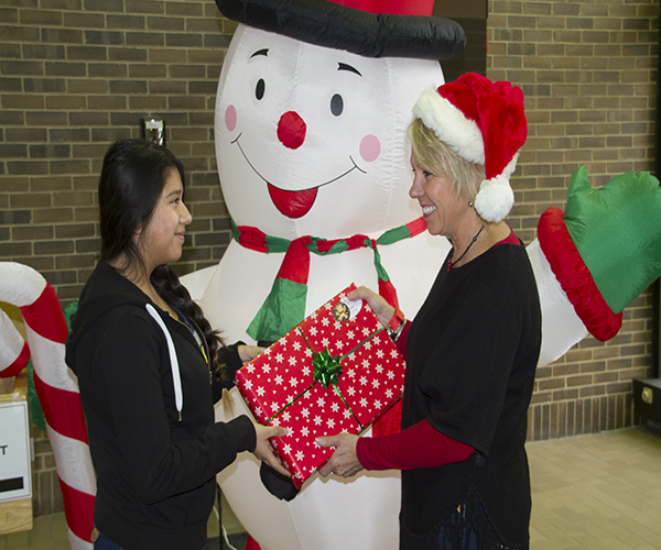 GIFT OF GIVING: Freshman Jennifer Vargas receives a gift from Glenview Youth Services, an organization that has provided financial assistance to her and her family during the holiday season for many years. Photo by Ashley Clark