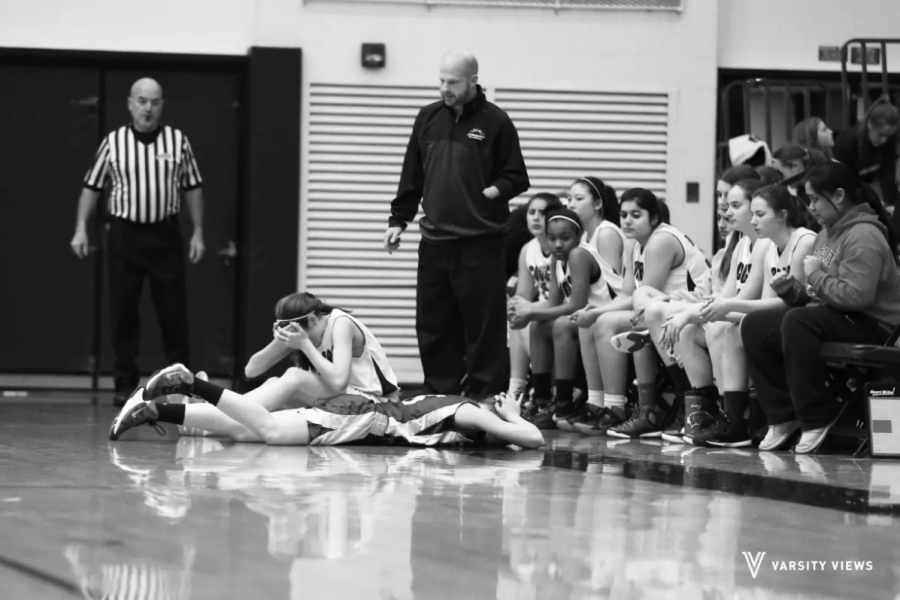CONCUSSION DISCUSSION: Lying face down on the basketball court during a game on Jan. 13, sophomore Lauren Meier struggles with a head inury, later diagnosed as a concussion. By the next school year, Illinois middle and high schools must fit concussion management to state standards, according to the Youth Sports Concussion Safety Act.