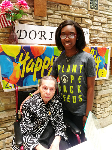 COMMUNITY CARETAKER: Attending the late Dorina Frishlander’s 97th birthday party, sophomore Mira-Cler Josaiah builds her relationship with the residents at Chestnut Square, an independent senior living community in Glenview. Josaiah has been volunteering as a caretaker for two-and-a-half years, and is considering a related career in the medical field. 